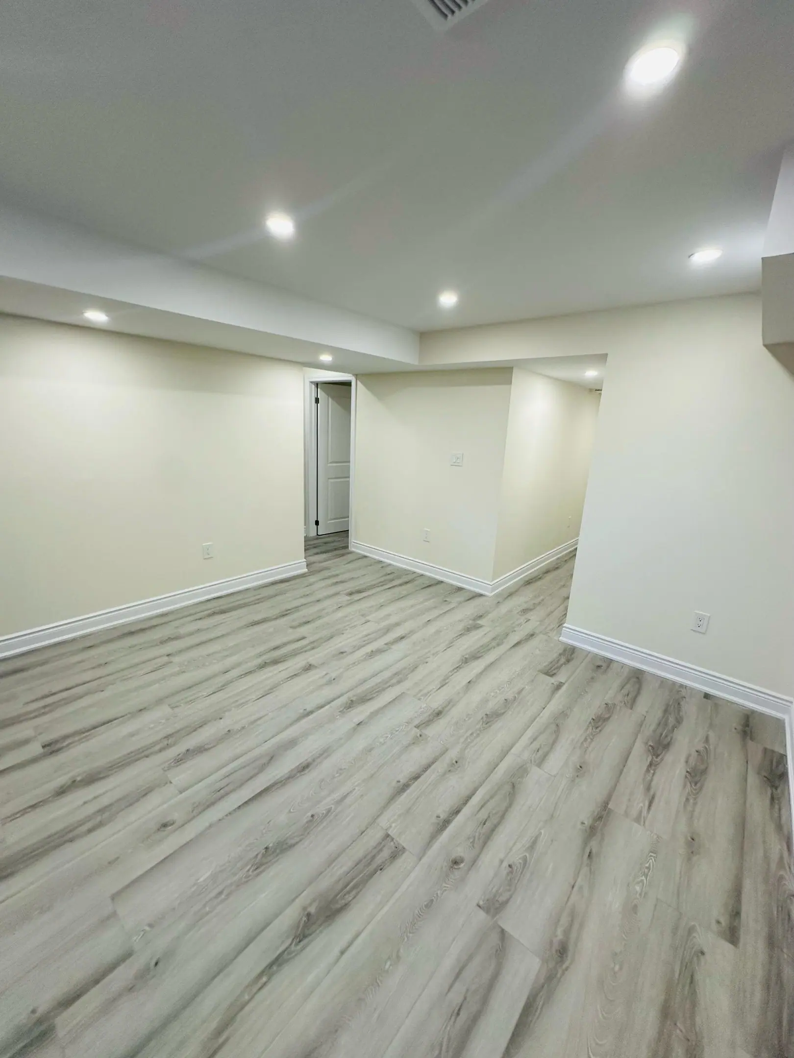 Basement living room with grey vinyl plank flooring