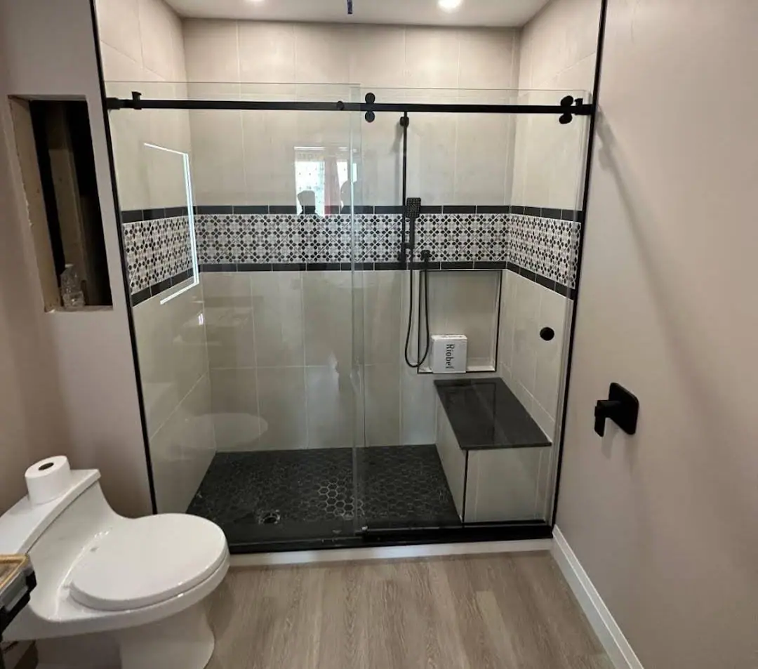 Walk-in shower with mosaic accent band and black fixtures