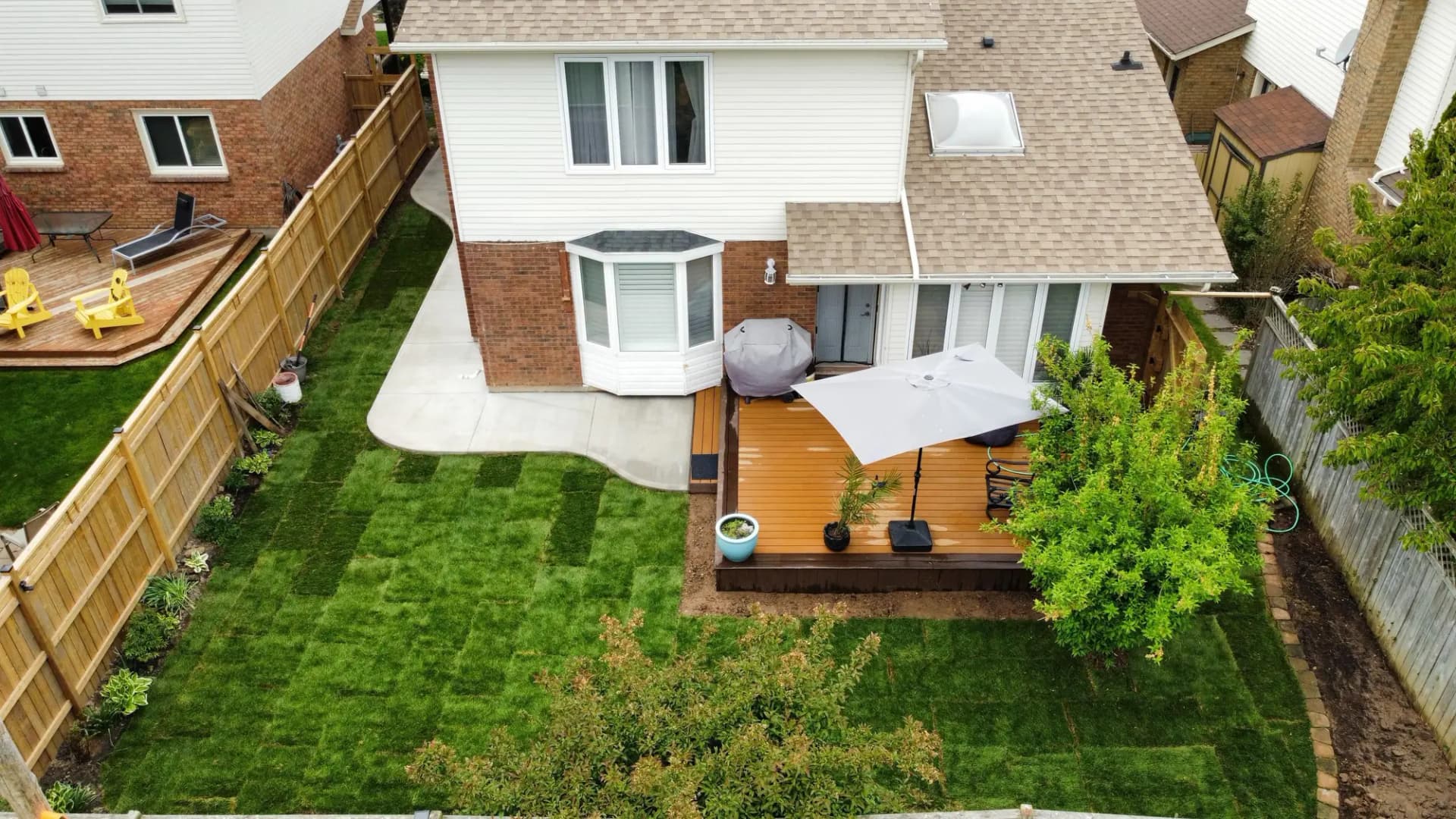 Aerial view of a backyard with new deck and fence