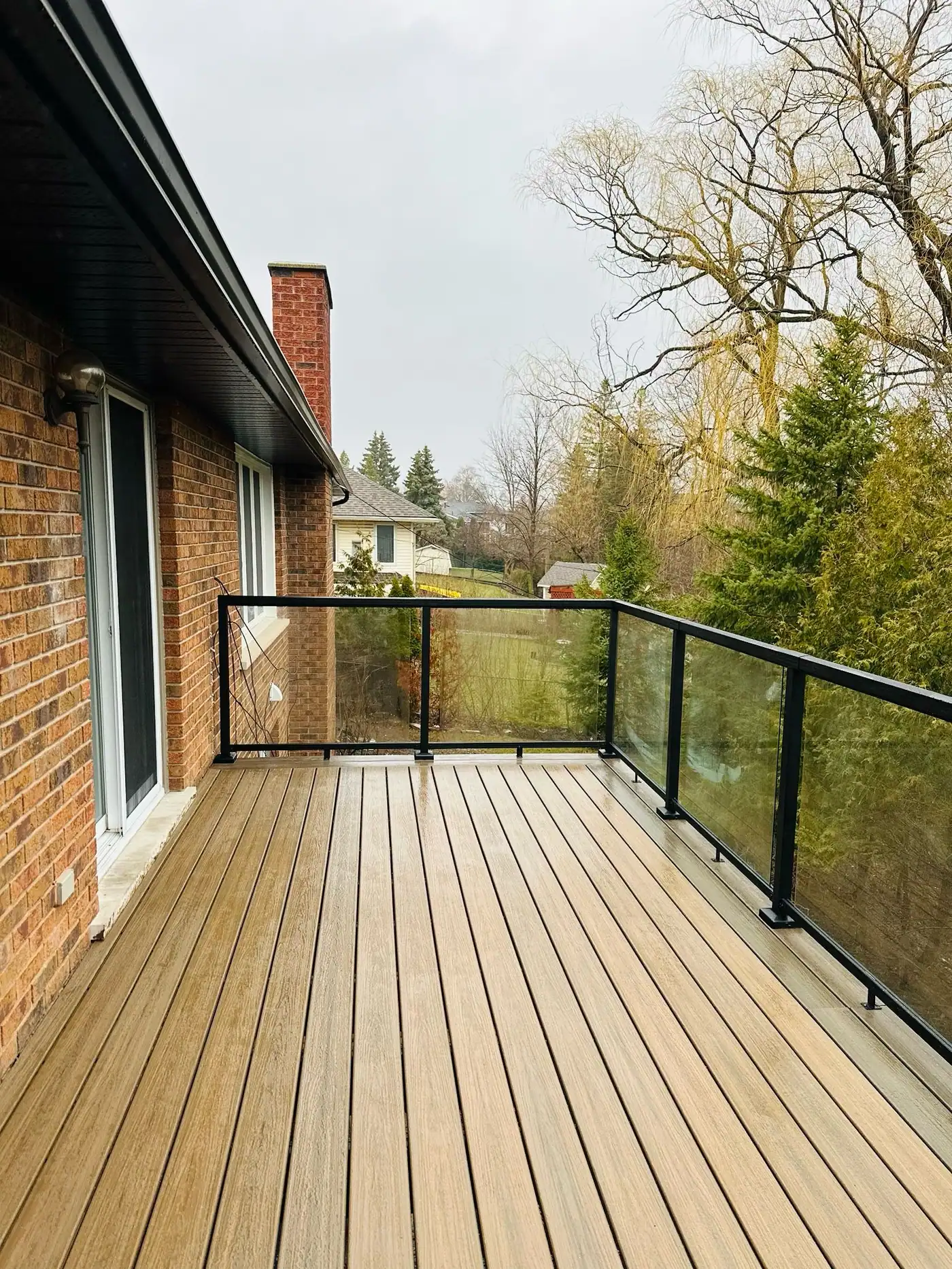 Composite deck with glass railing overlooking trees