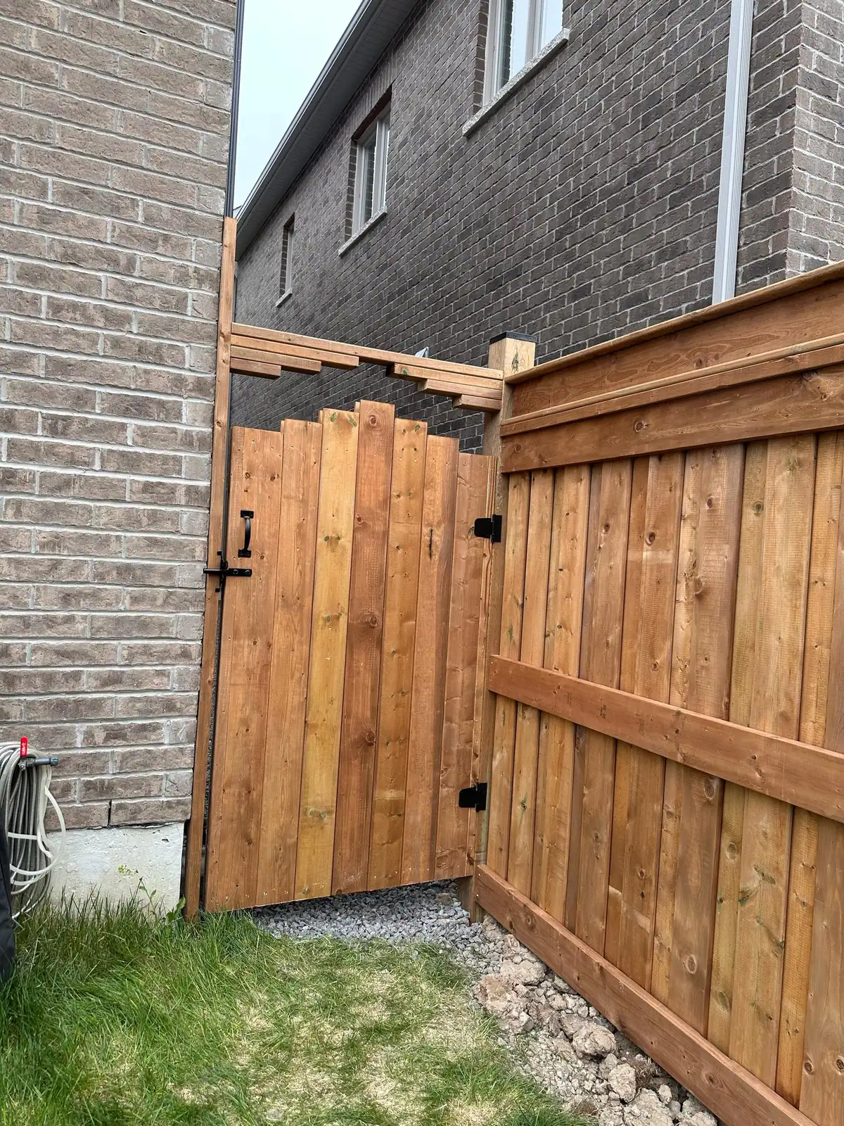 Wood fence with matching gate beside a brick house