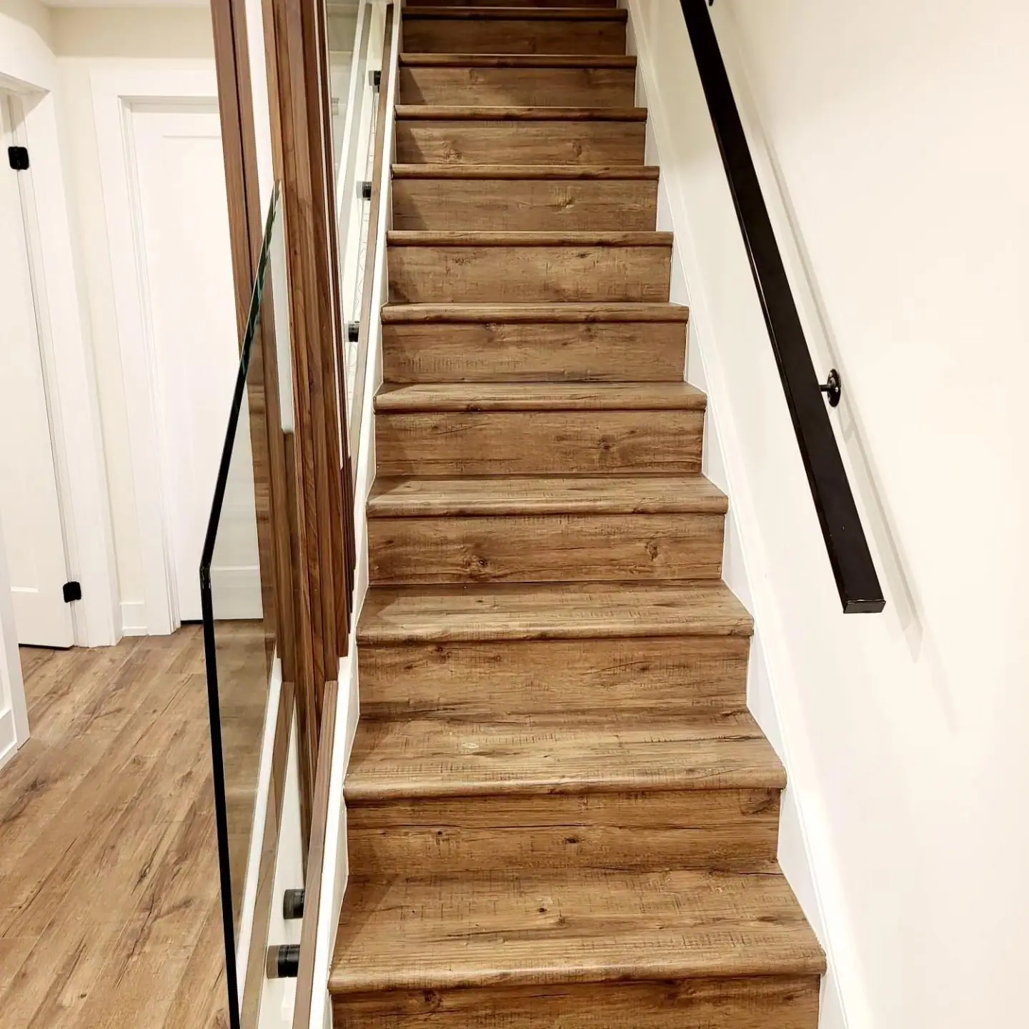 Oak stair treads with black handrail and glass panel