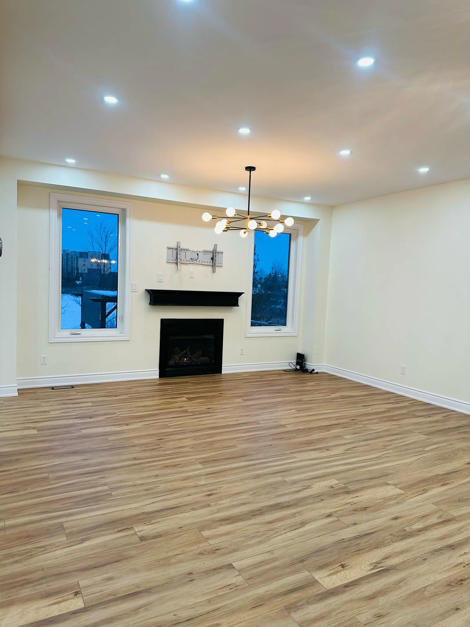 Family room with fireplace, chandelier and wide-plank floors