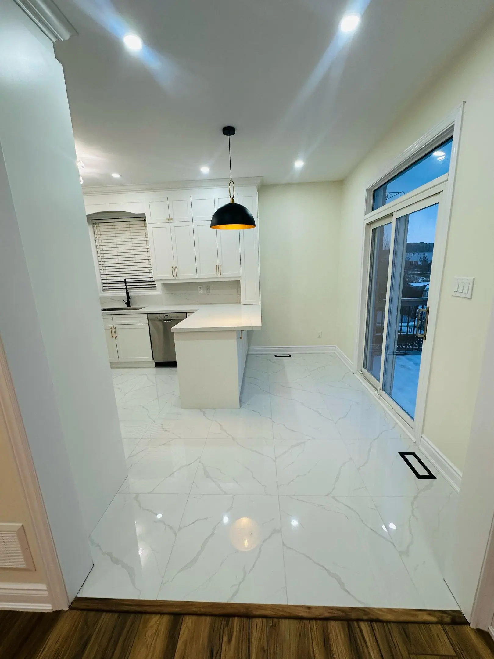Galley kitchen with white cabinets and porcelain floor