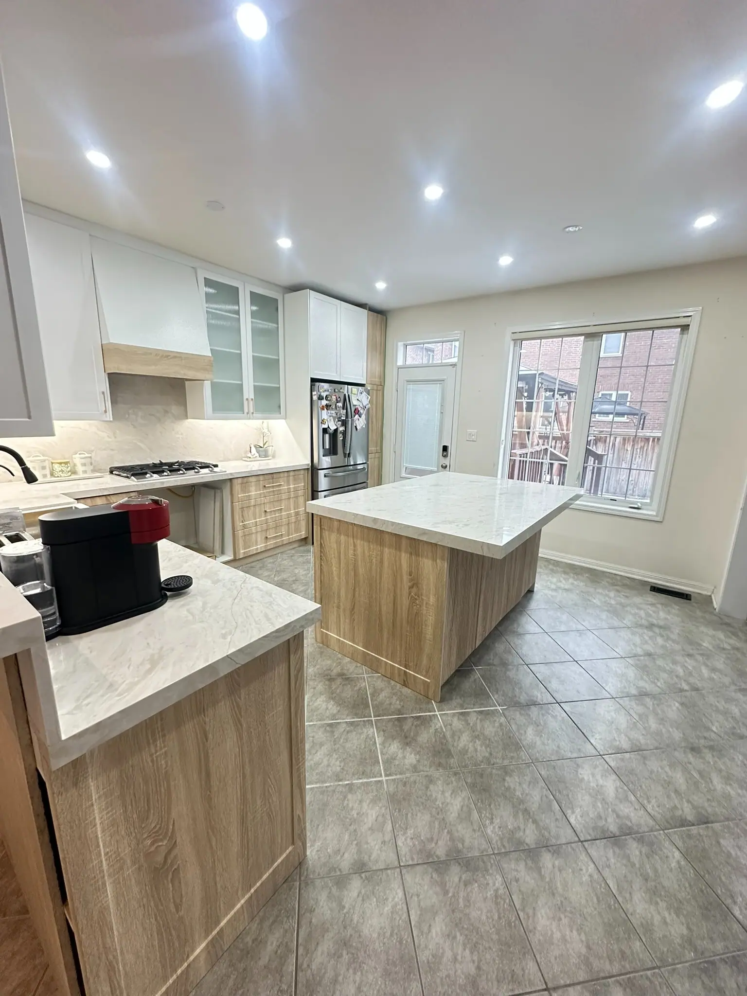 Two-tone kitchen with wood island and white upper cabinets