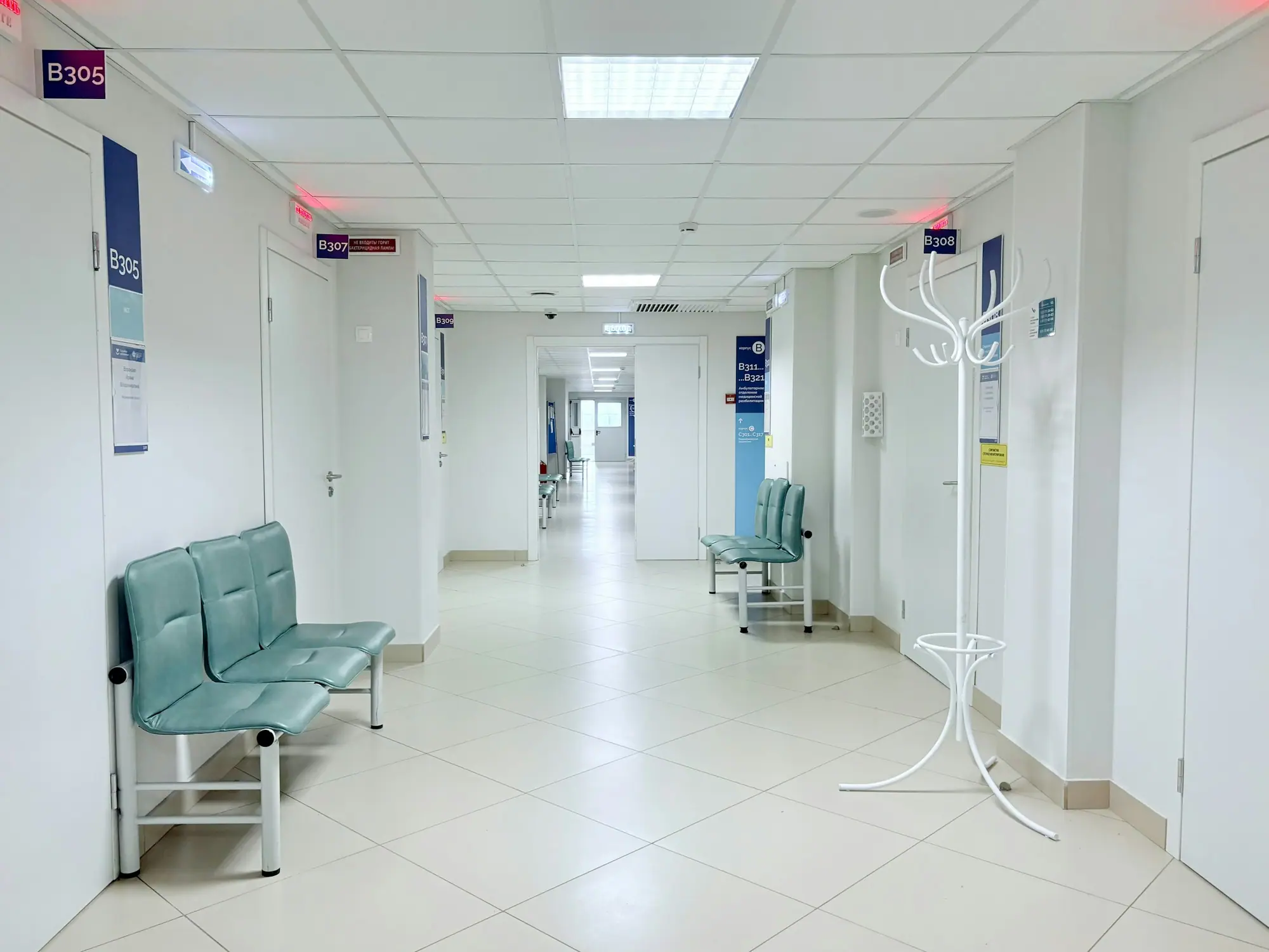 Clinic corridor with waiting benches and exam room doors