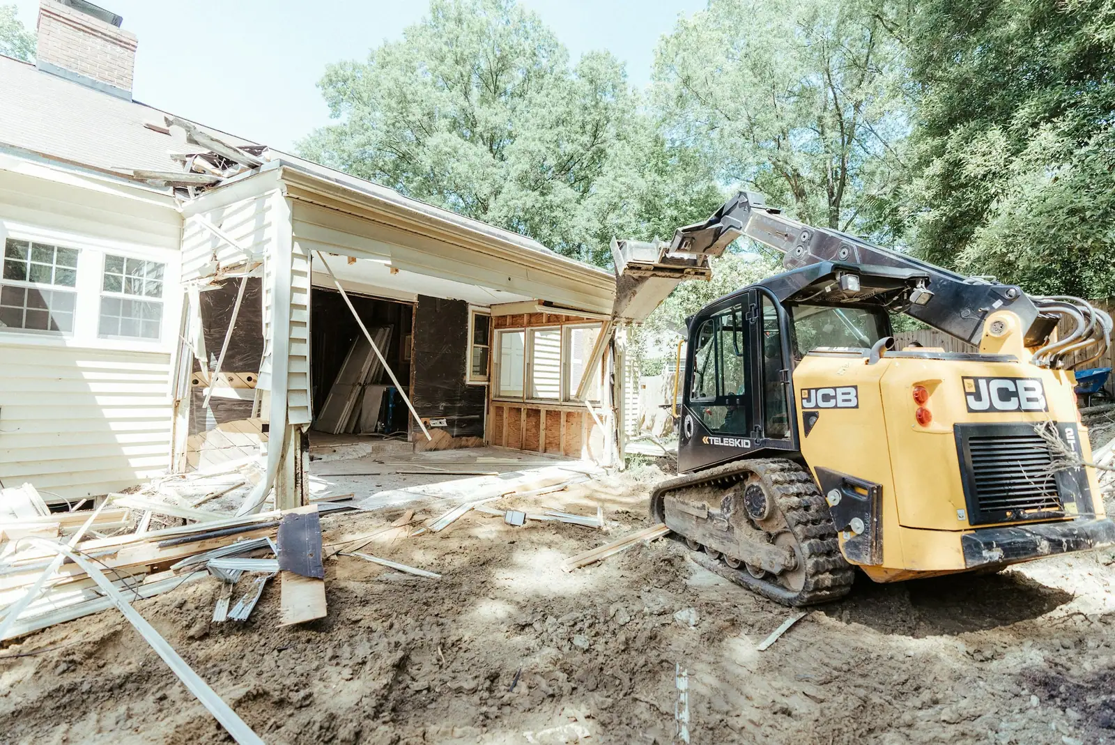 Compact track loader excavating for a rear house addition