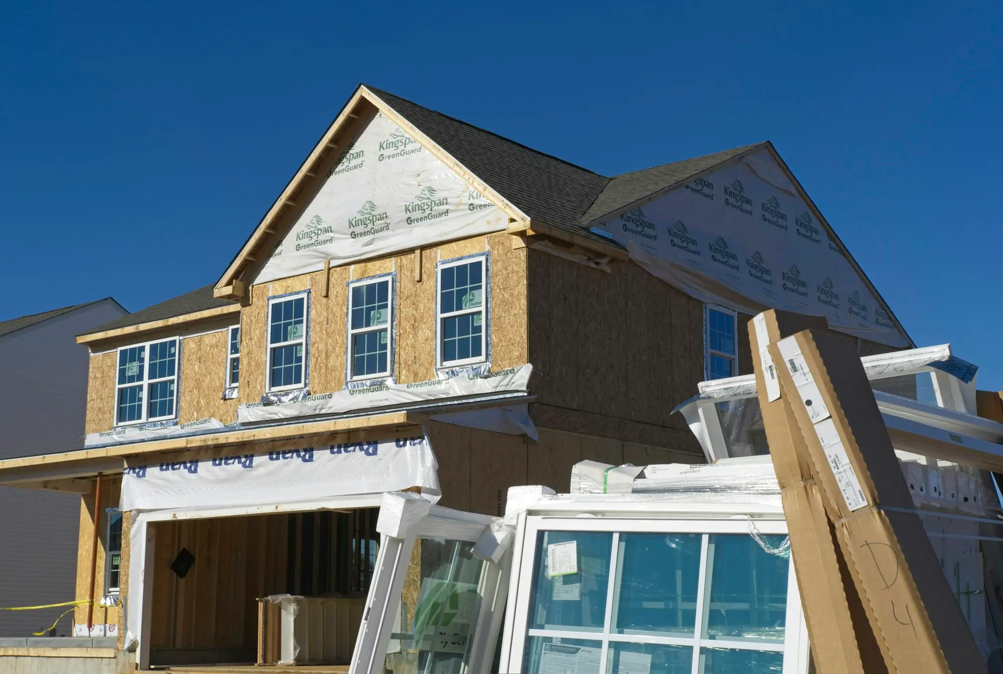 House extension sheathed in plywood with new windows staged in front