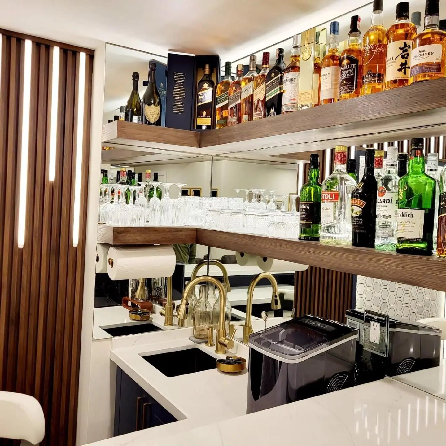 Basement bar with backlit liquor shelves and quartz counter