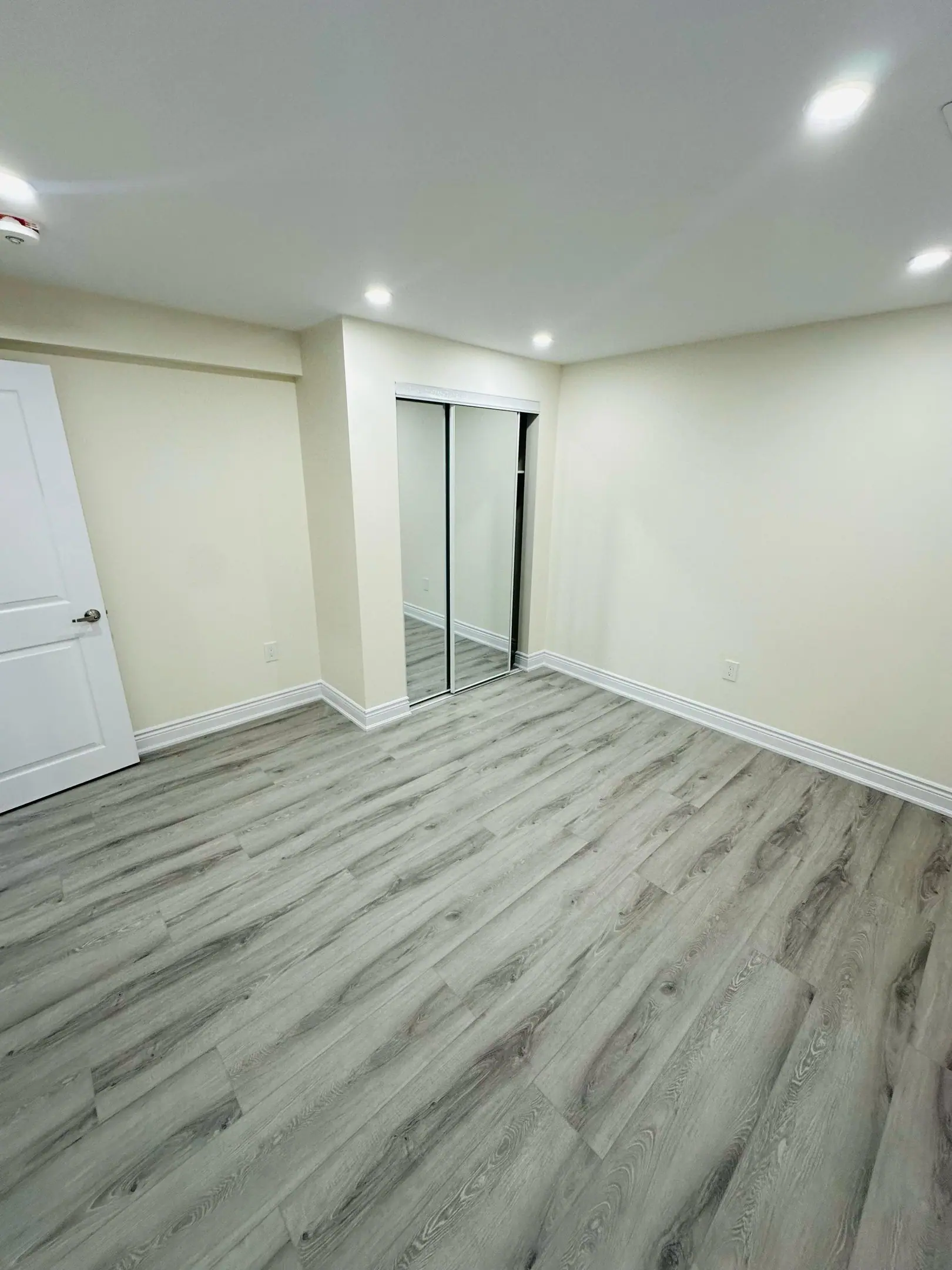 Finished basement bedroom with mirrored closet doors