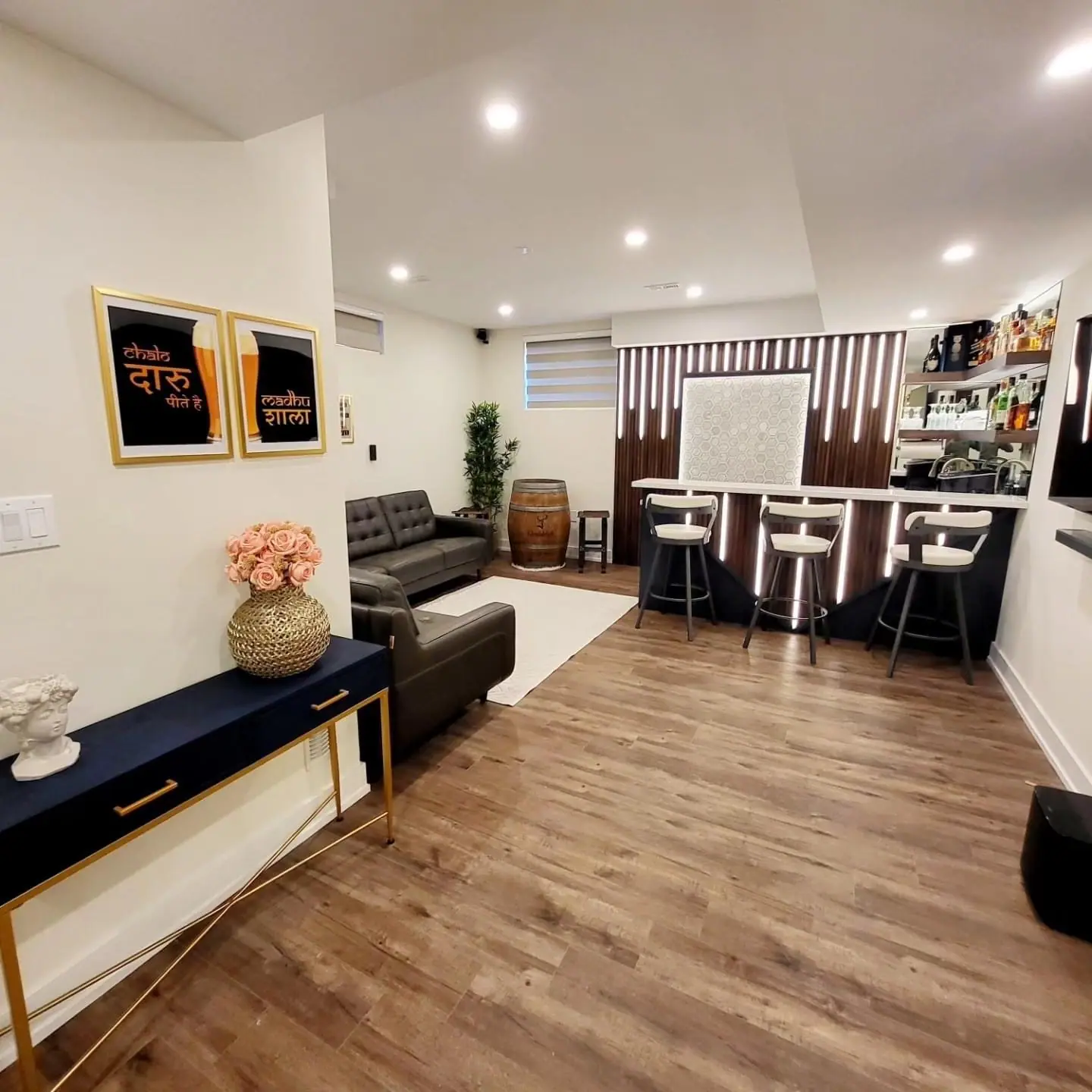 Finished basement family room with vinyl plank floor, sofa and bar seating