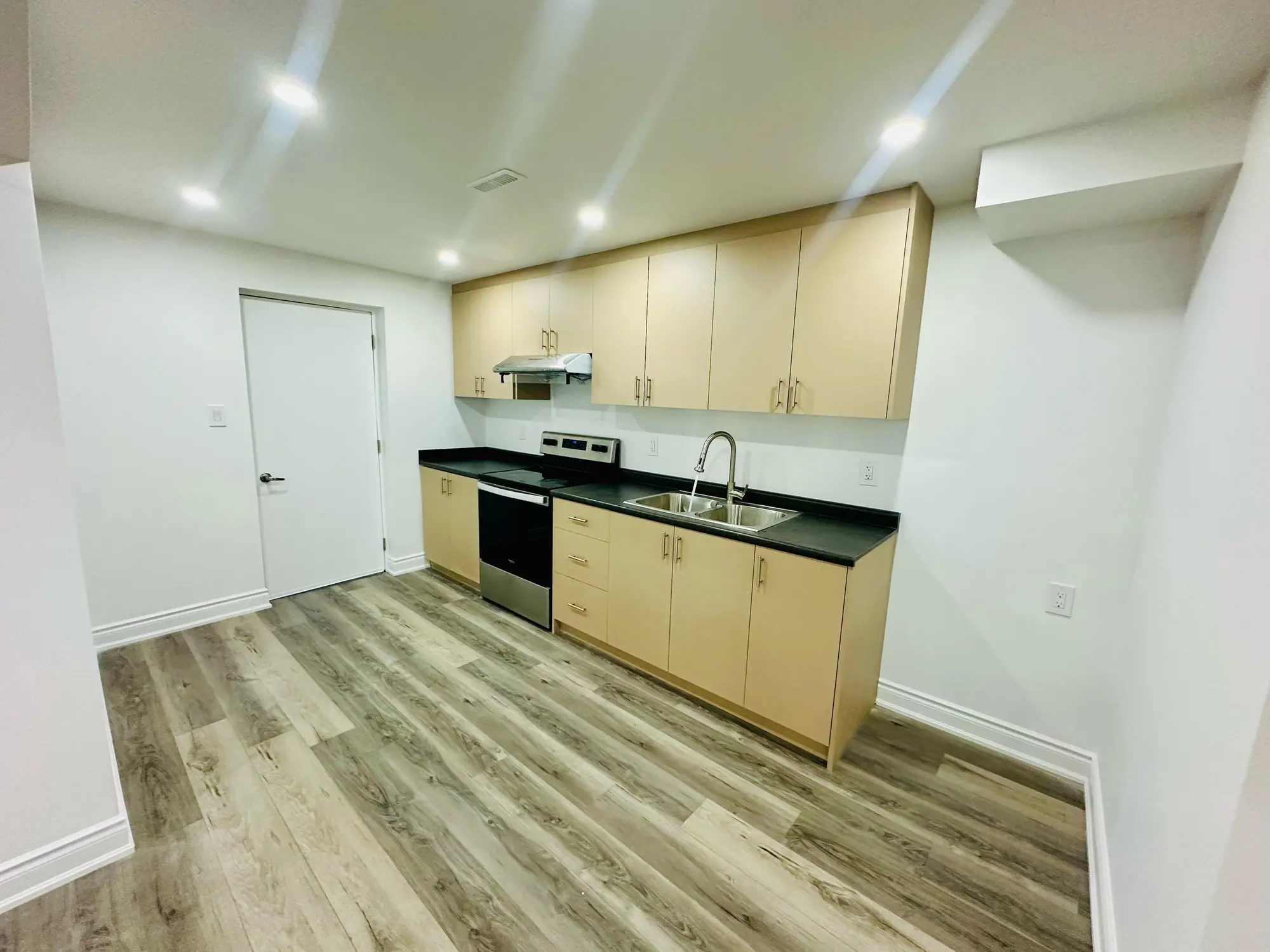 Legal basement apartment kitchen with maple cabinets and stainless range