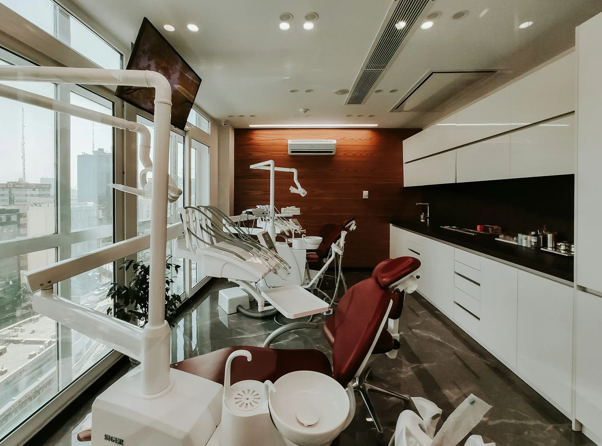 Dental treatment room with chair, overhead light and storage
