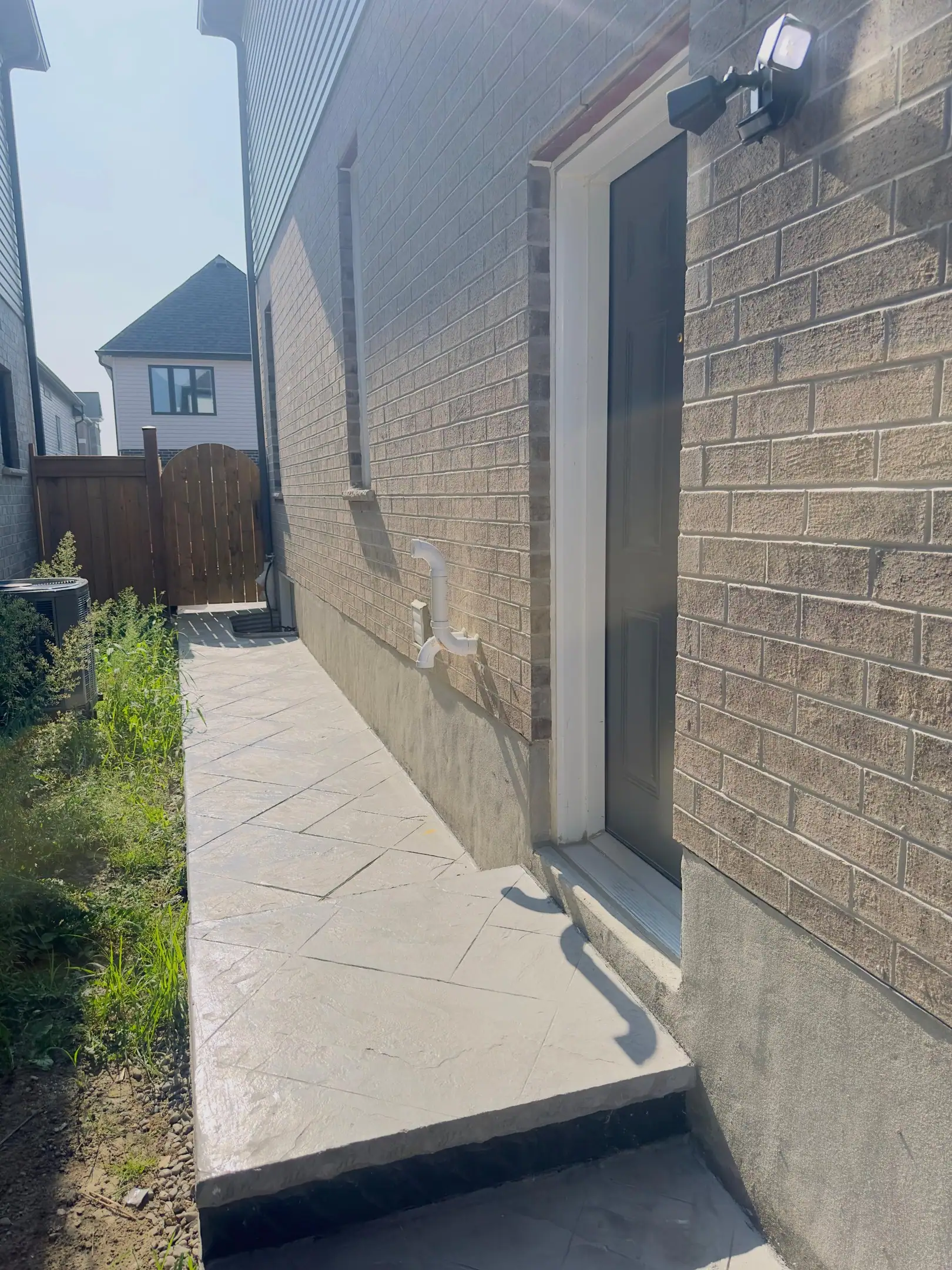 Side entrance walkway along a brick house