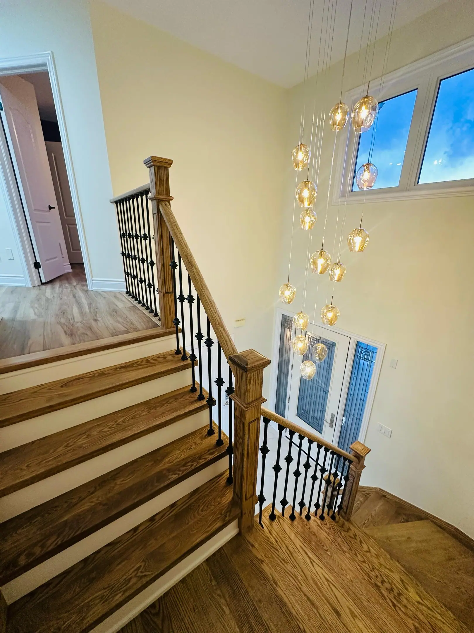 Oak staircase with iron balusters below two-storey windows