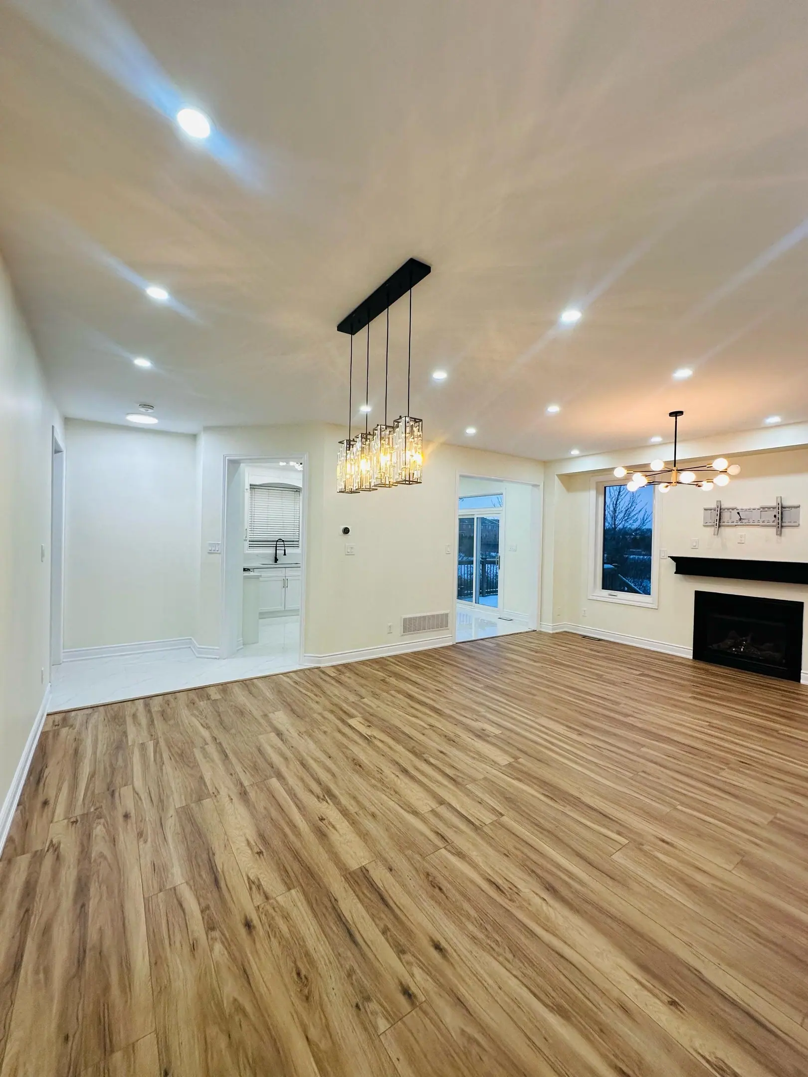 Open-concept main floor with linear pendant and fireplace