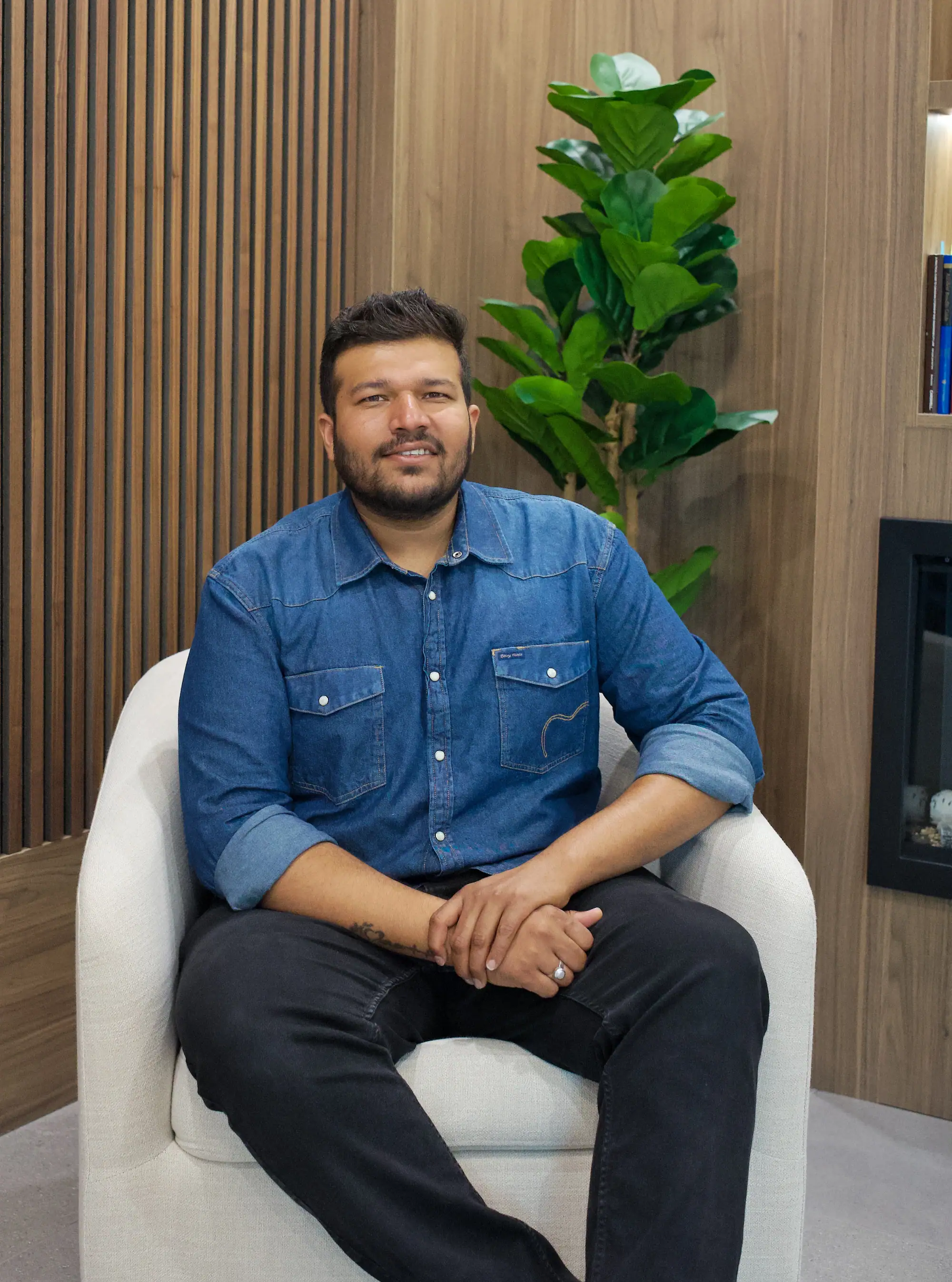 Naitik Bhavsar, founder of CarpentryBoys Inc., seated in a walnut-panelled room